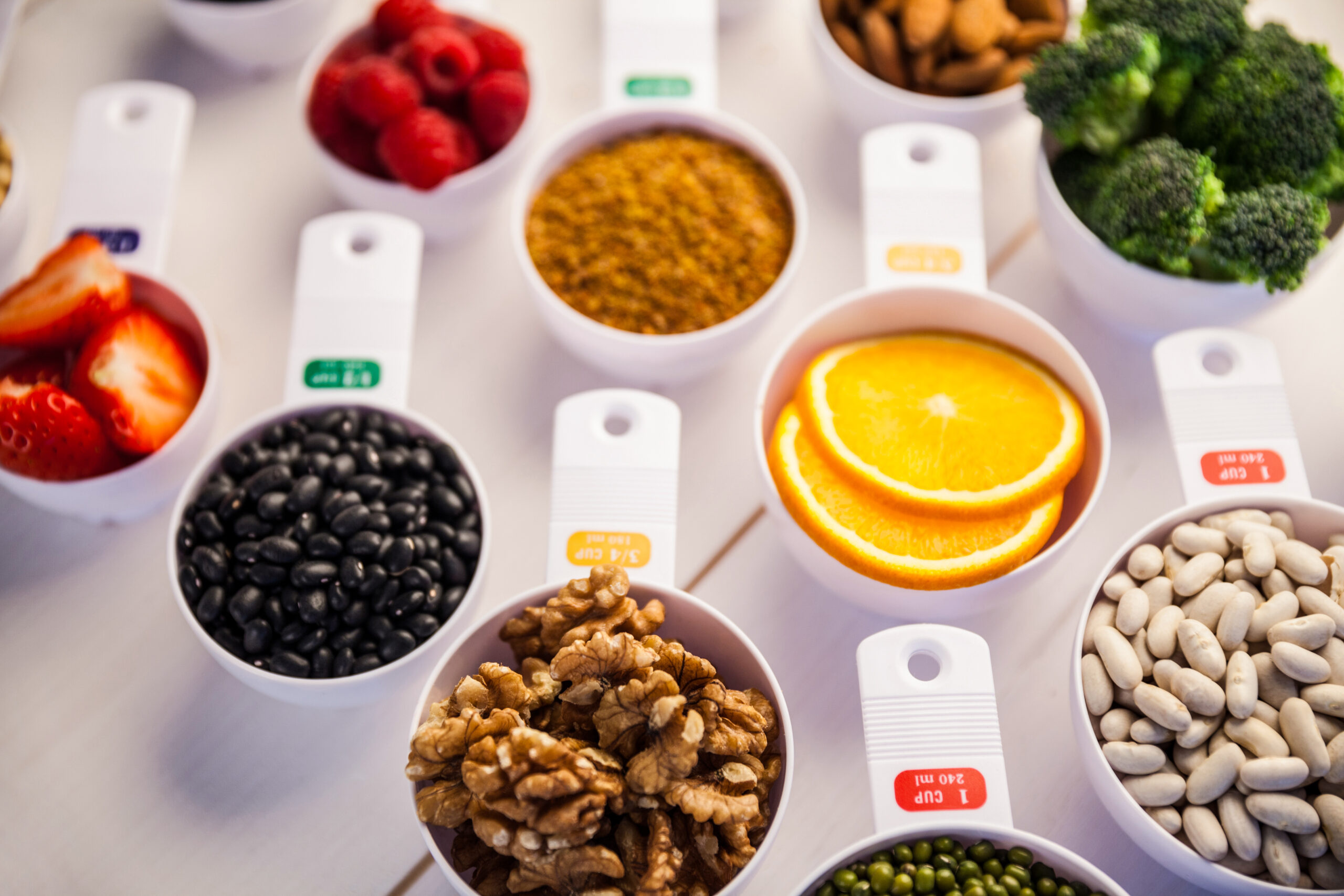 Nutrition Coaching Portion cups of healthy ingredients on wooden table